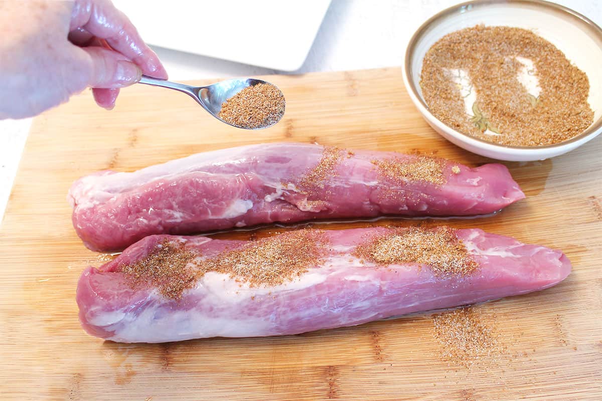 Sprinkling dry rub on pork.