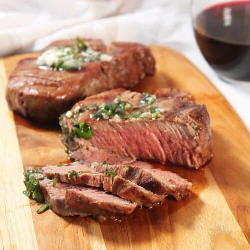 Sliced grilled filet mignon with herb garlic butter.