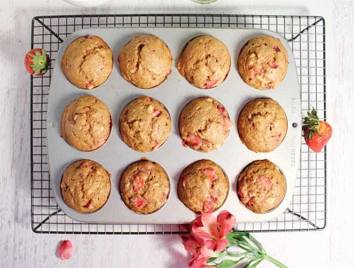 Baked muffins in muffin tin cooling on wire rack.