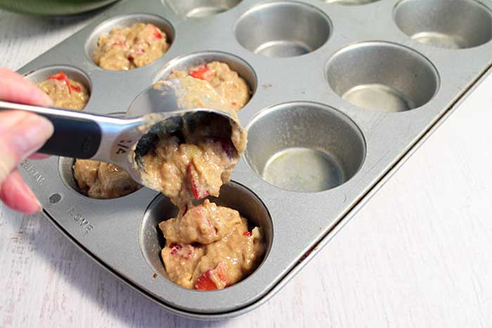 Scooping batter into muffin tin.