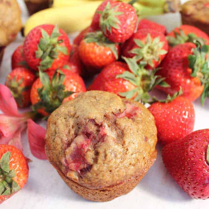 Single muffin surrounded by strawberries.