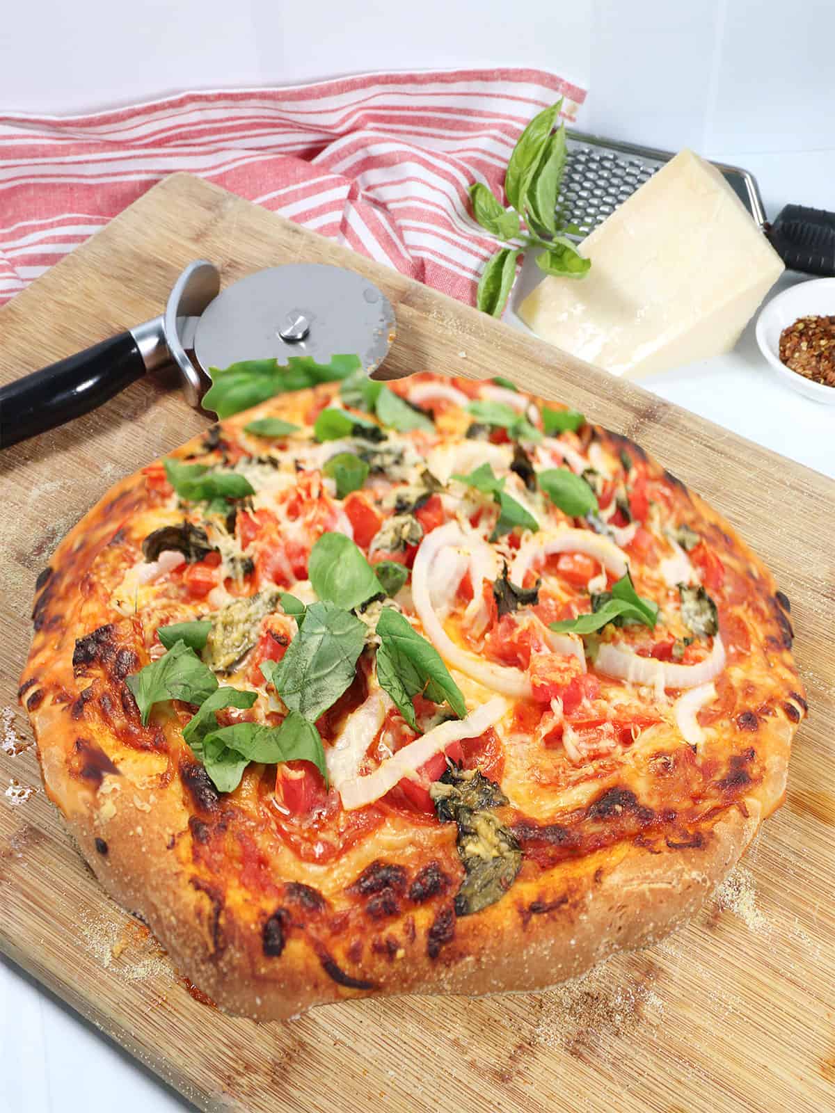 Baked pizza on wooden cutting board.