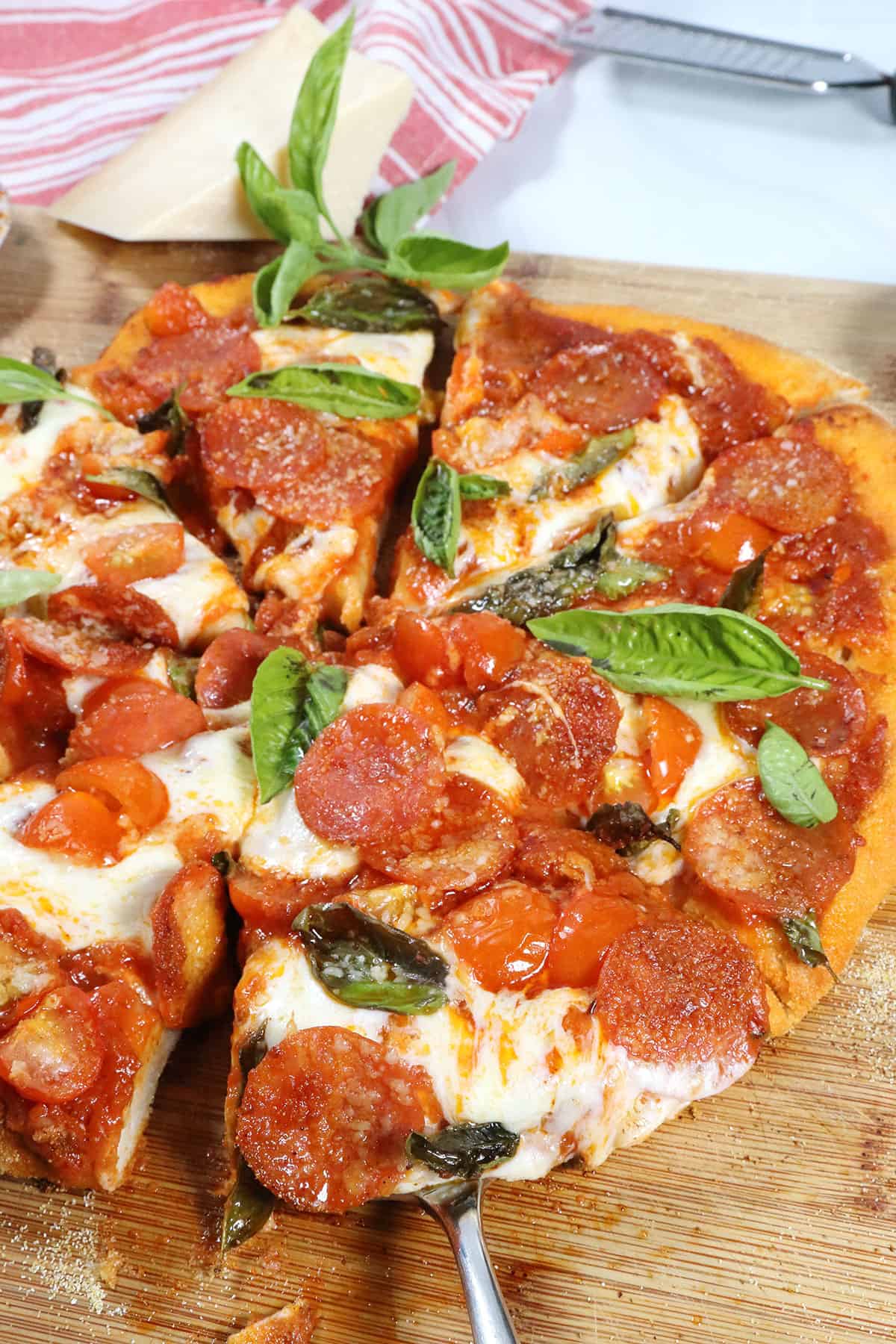 Lifting a slice from our easy homemade pepperoni pizza.