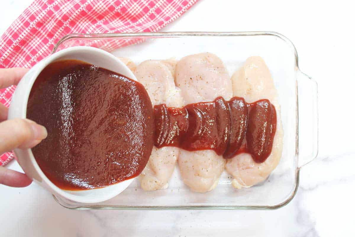 Pouring BBQ sauce over chicken..