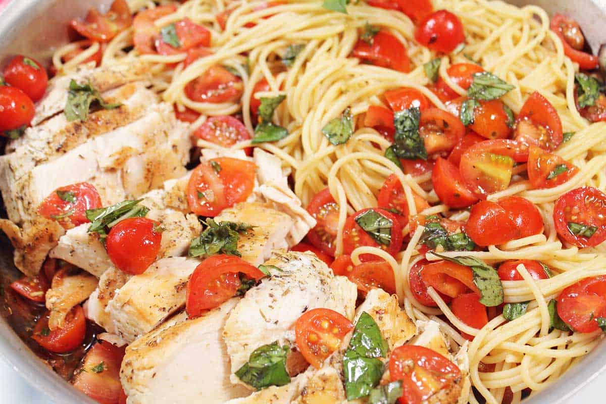Closeup of bruschetta chicken with pasta.