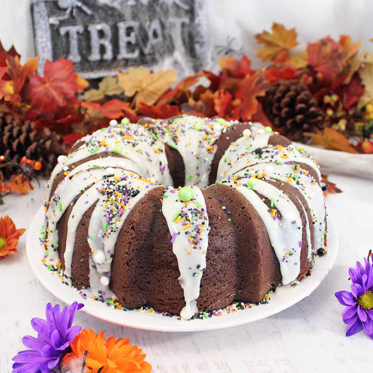 Finished chocolate bundt cake on table with fall leaves.