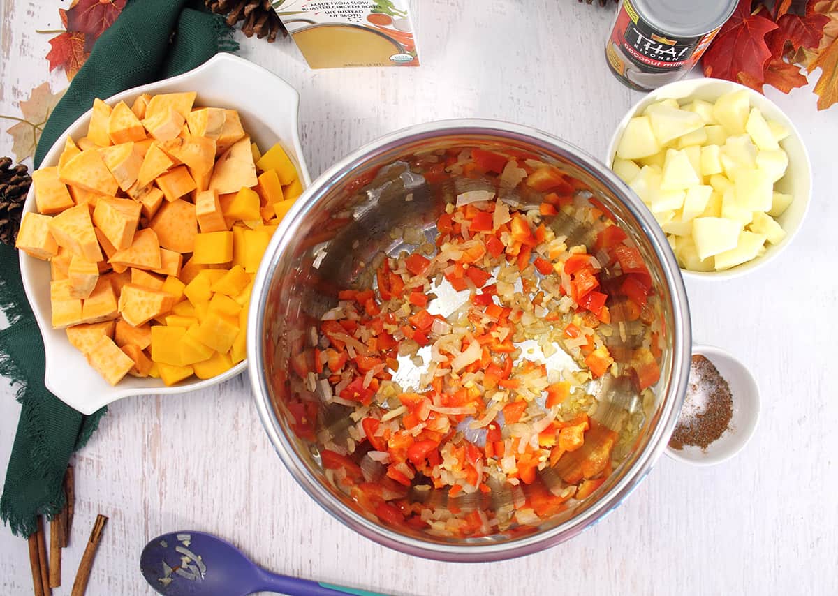 Chopped vegetables and fruit around sauteed onion, red pepper and garlic.