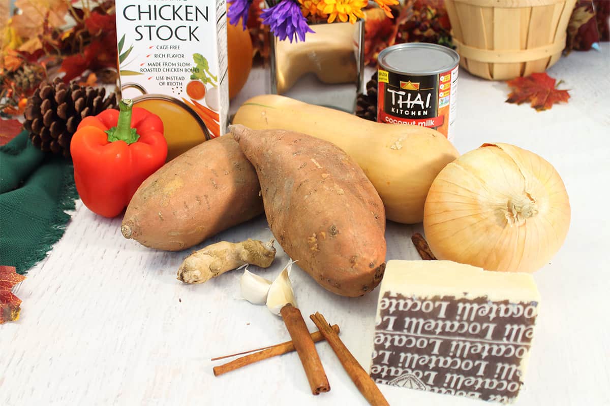 Ingredients for butternut squash soup with apples on white table.