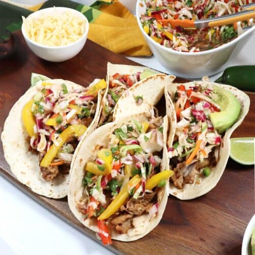 Korean Pork Tacos on tortillas with crispy slaw in back.