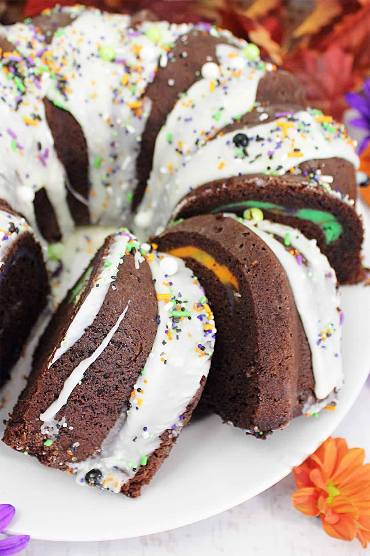 Sliced chocolate cream cheese bundt cake on serving plate.