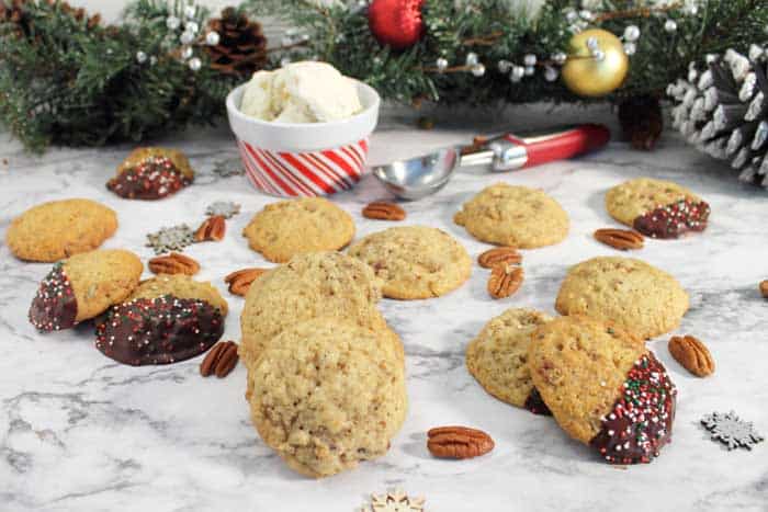 Butter Pecan cookies laid out on white table with ice cream in background.