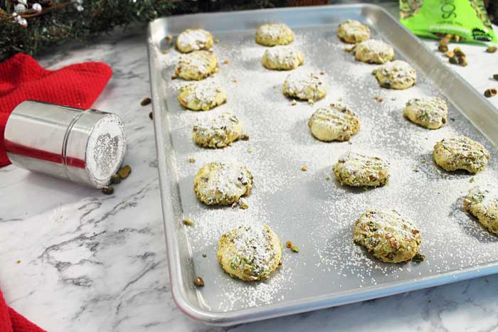 Pistachio Whipped Shortbread Cookies dusting with sugar
