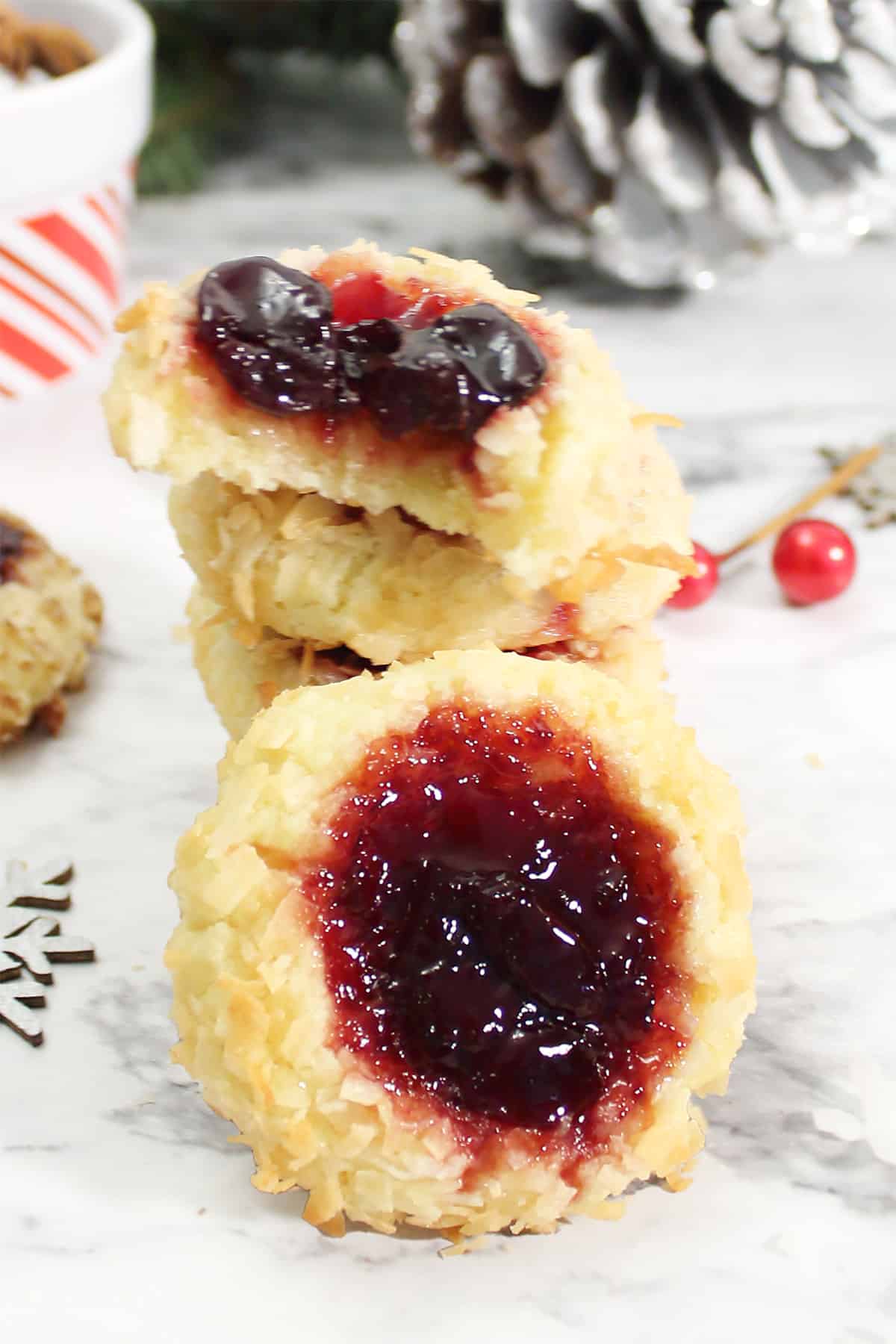 Closeup of cherry jam thumbprint cookies in marble table.