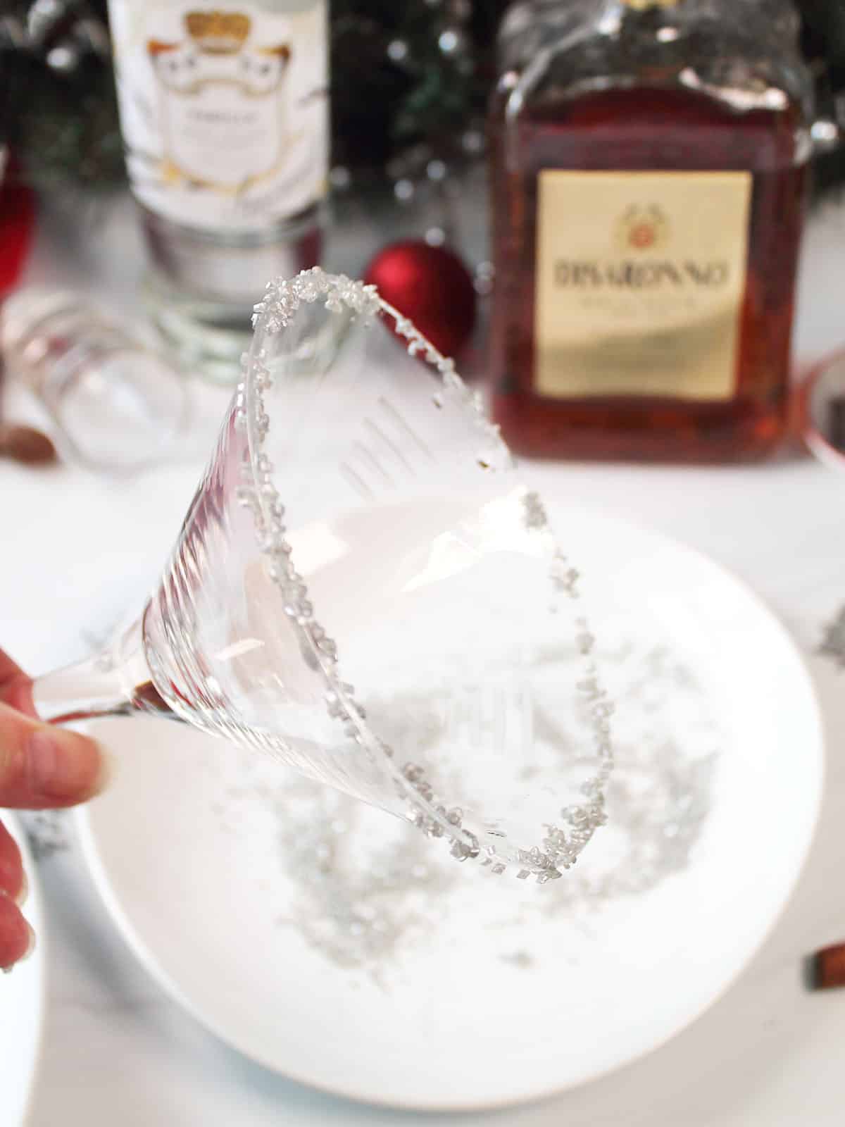 Dipping the martini glass in silver glitter sugar.