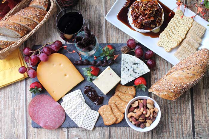 Cheese board featuring kahlua pecan baked brie with crackers.