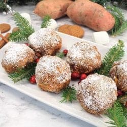 Sweet Potato Puffs on white serving platter with cranberries and pine sprigs.