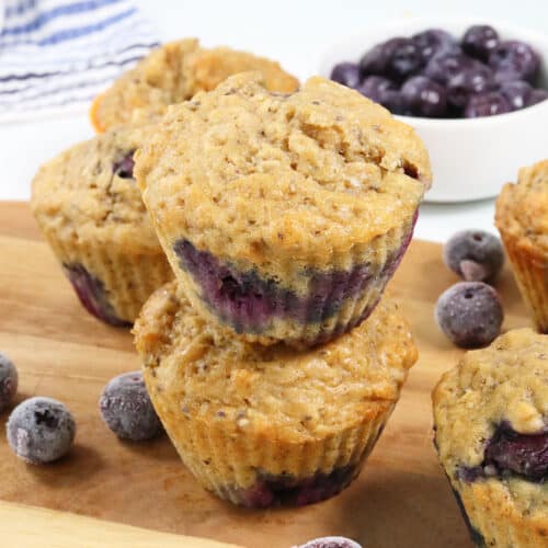 Stacked Blueberry Oatmeal Muffins on wooden board.