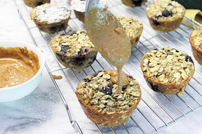 Blueberry Yogurt Oatmeal Muffins drizzling with almond butter