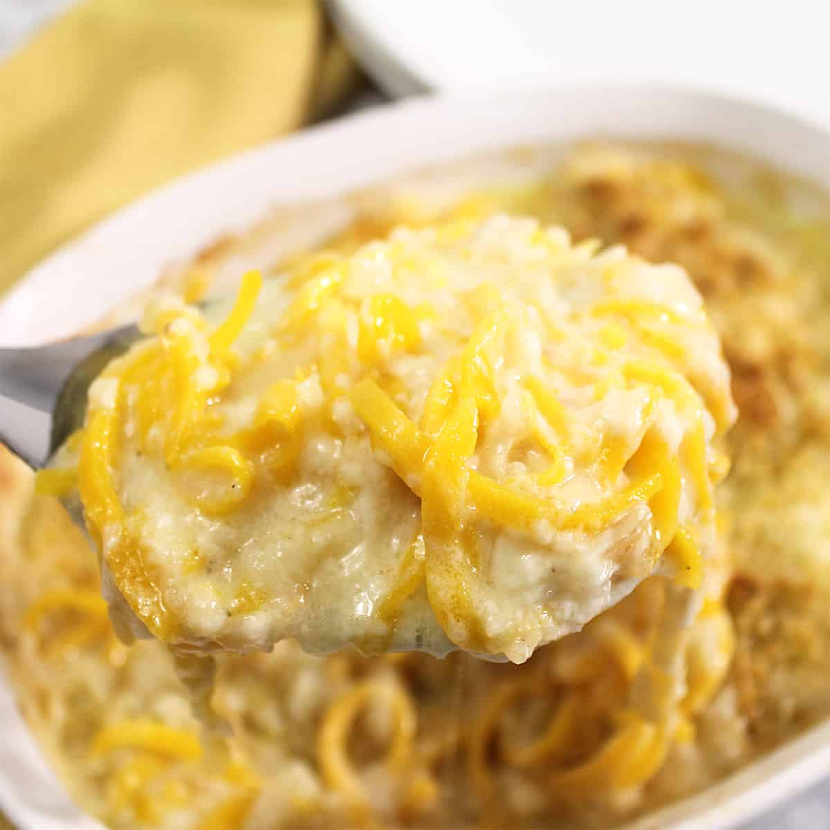 Spoonful of mac and cheese over casserole.