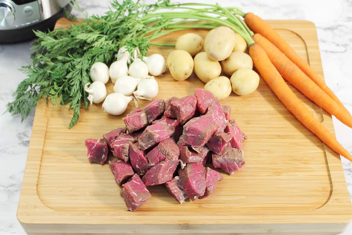 Ingredients for stew on cutting board.