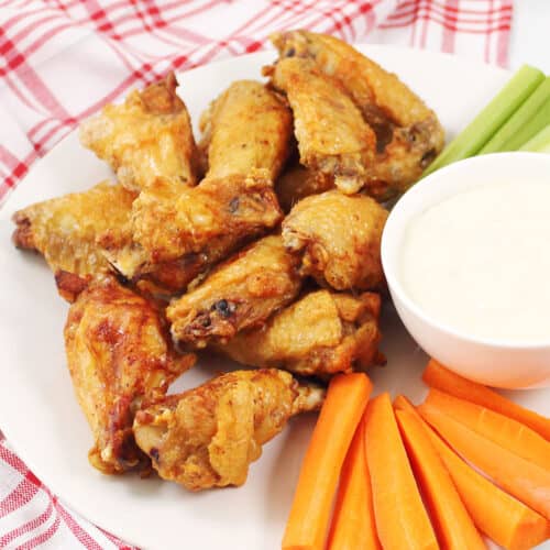 Crispy Air Fryer Chicken Wings on platter with blue cheese dressing and veggies.