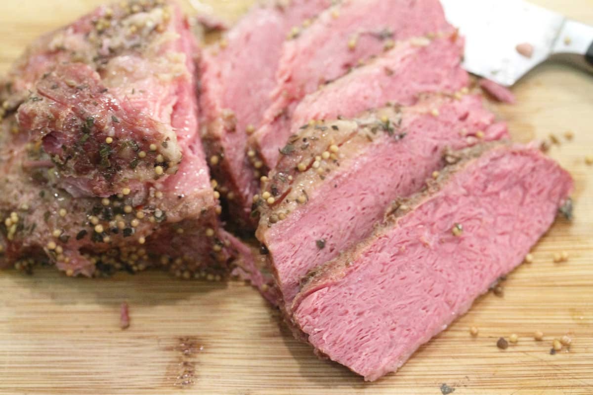 Closeup of sliced corned beef on cutting board.