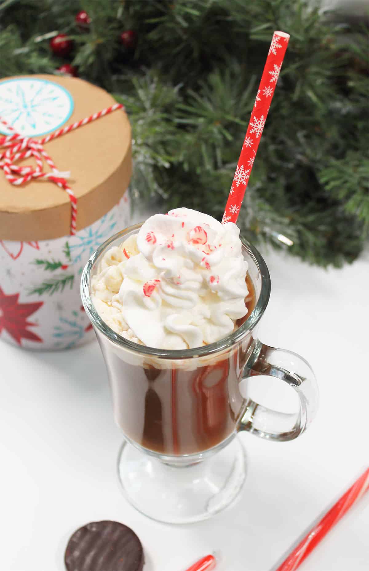 Single peppermint coffee drink garnished with whipped cream and candy cane pieces.