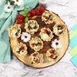 Baked empanadas overhead with tomatoes and daisies square