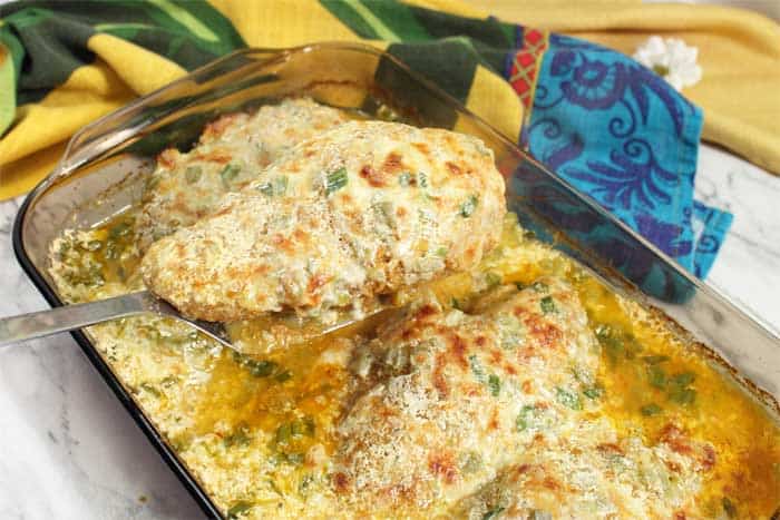 Lifting a cheesy chicken breast out of casserole dish