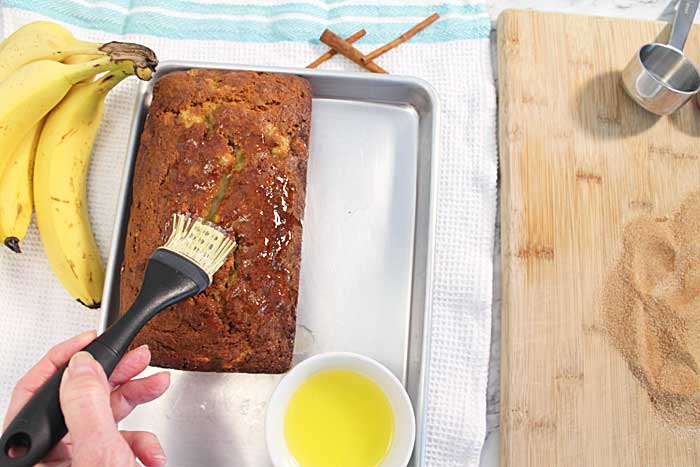 brushing banana bread with butter
