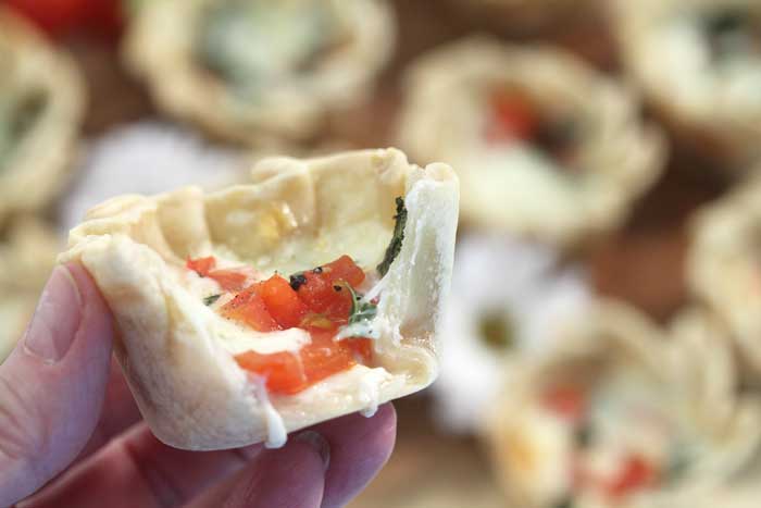 Holding empanada with bite and cheese dripping