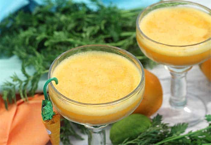 closeup of 2 margaritas with carrot greenery and pastel napkins