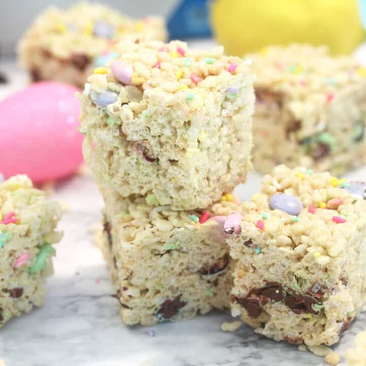 Double stack of Easter rice krispie treats with colorful eggs around them.