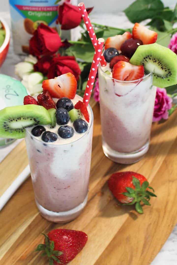 2 Cherry Smoothies on wooden board with roses.