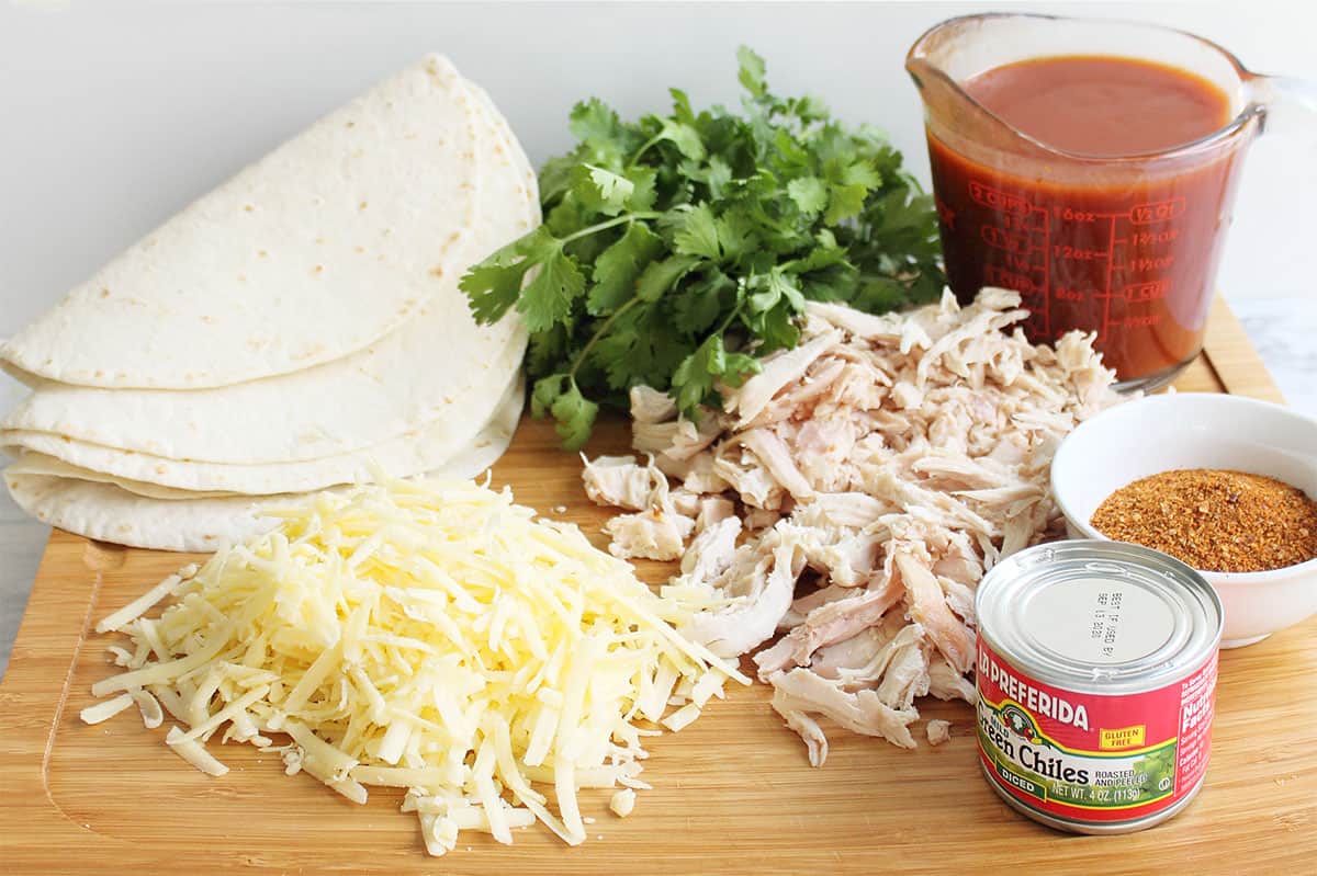 Enchilada ingredients on cutting board.