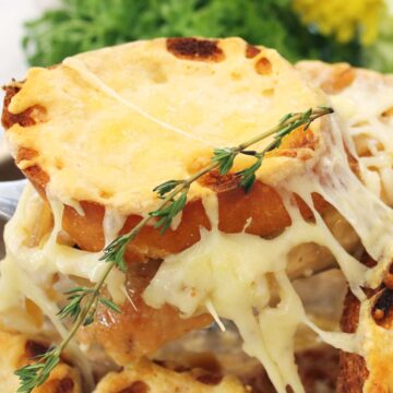 Liftin serving of French onion smothered chicken out of skillet.