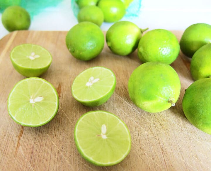 Key limes on wooden cutting board.