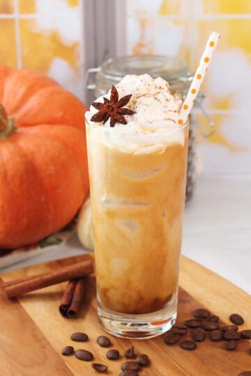 Garnished pumpkin latte in glass with ice.