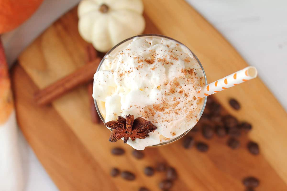 Iced Pumpkin Latte overhead showing whipped cream, nutmeg and star anise garnish.