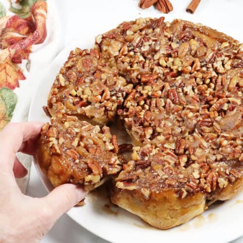 Grabbing a maple pecan sticky bun from plate.