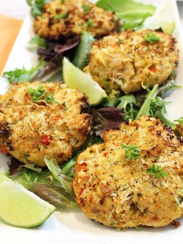 Closeup of cooked tuna fish cakes on white plate.