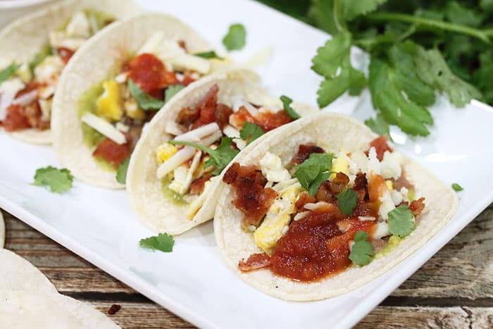 Nestled breakfast tacos with filling showing.