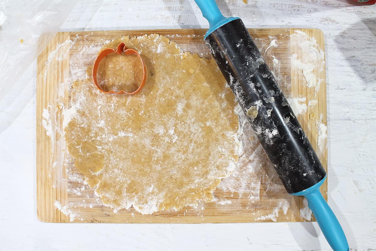 Roll out dough and use cookie cutter to cut pumpkin-shaped cookies.