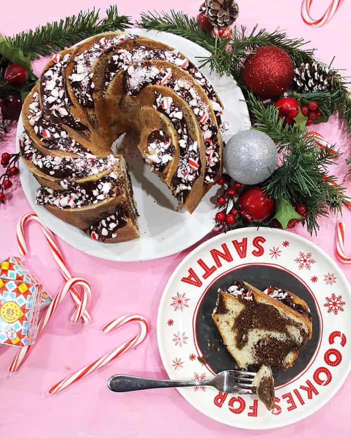 Sliced cake with piece of cake with a bite on fork on Santa plate.