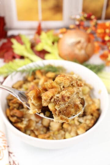 Spoonful of Homemade Turkey Stuffing over serving bowl.