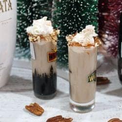 2 pecan pie shots with Rum Chata and Chrsitmas trees in background