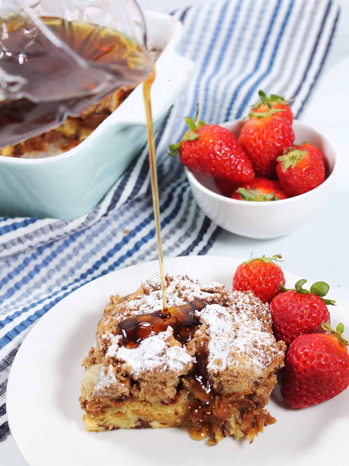 Pouring syrup over baked cinnamon french toast.