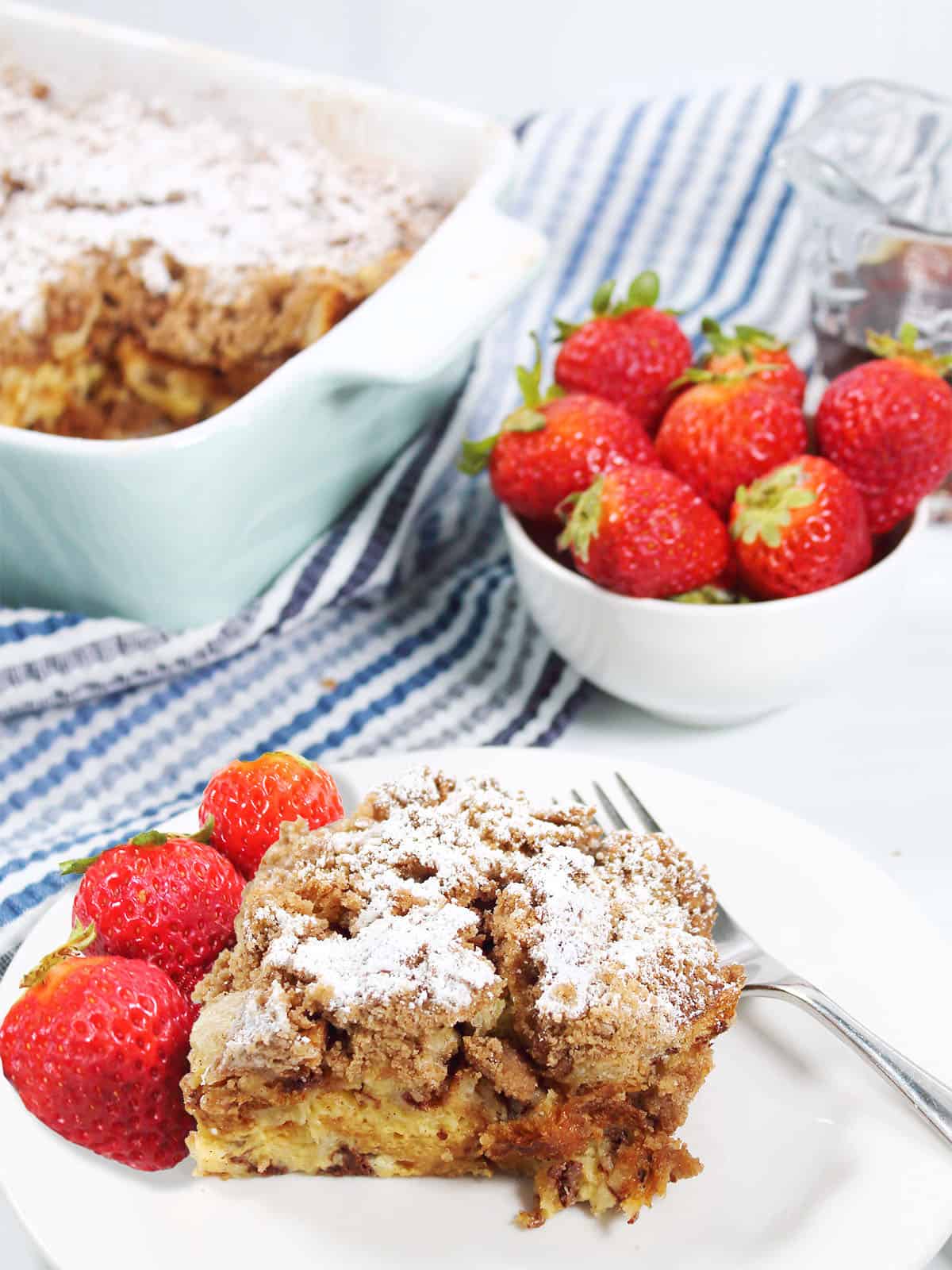 Overnight Cinnamon French Toast plated in front of casserole.