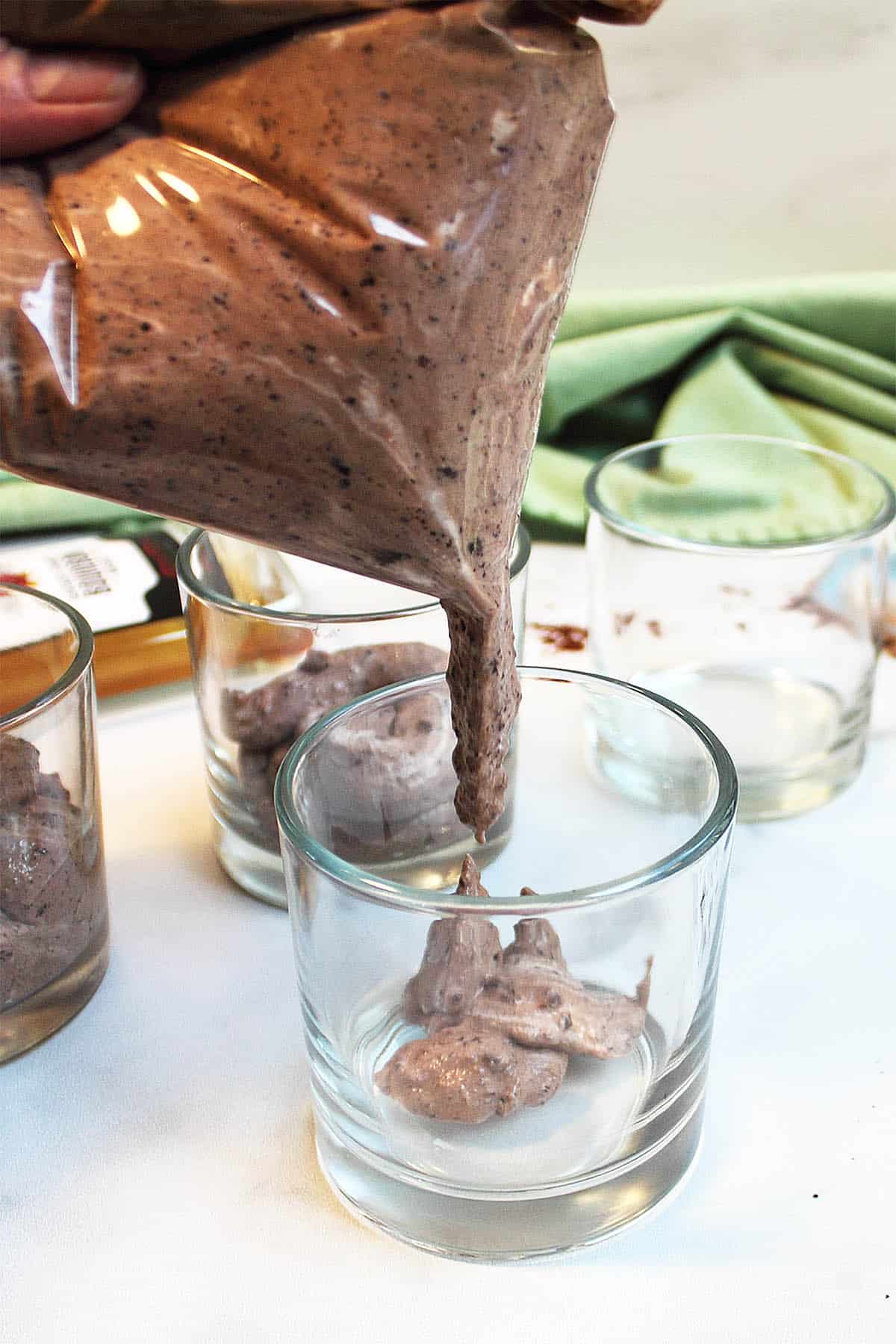 Filling small dishes with mousse by using a resealable plastic bag.