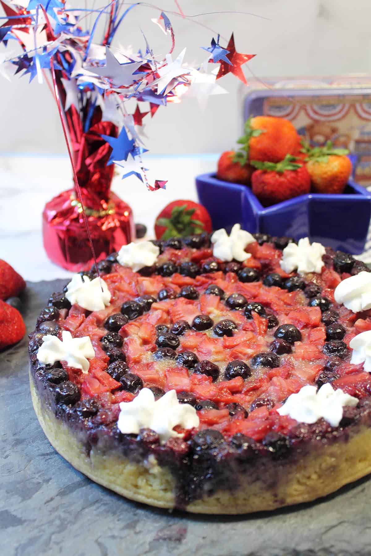 Decorated Berry Upside Down Cake on slate.